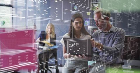 Business Colleagues Analyzing Data Together in Modern Office