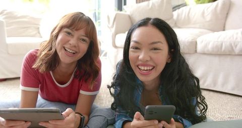 Happy Friends Enjoying Social Media Together on Cozy Day Indoors