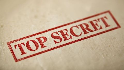 Diagonal red top secret stamp on beige textured paper showing distressed ink