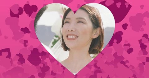 Bridal joy smiling asian bride gazing upward in heart cutout with pink heart pattern