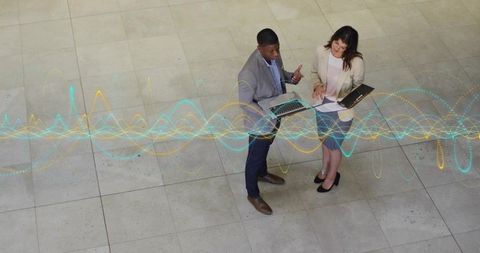 Colleagues Analyzing Data with Digital Overlay in Corporate Lobby
