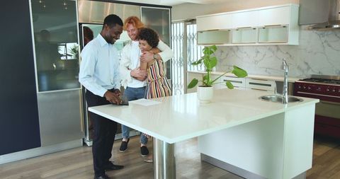 Happy couple finalizing purchase with smiling estate agent