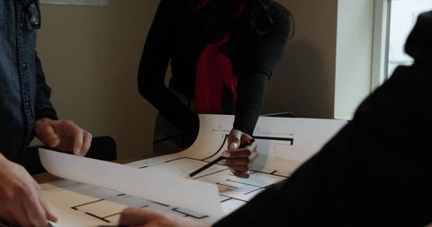 Architects Collaborating Over Blueprint in Office