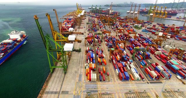 Aerial perspective showcasing bustling shipping port with rows of colorful containers and towering cranes. Ideal for illustrating global trade, supply chain management, logistics industry, and maritime transport. Suitable for use in articles, reports, business websites, and educational materials.