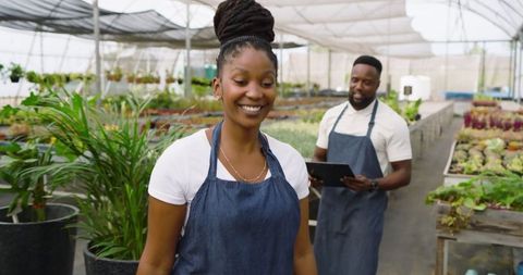Smiling Coworkers Working Together in Lush Greenhouse