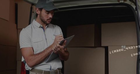Delivery driver checking clipboard in cargo van with stacked boxes and inventory