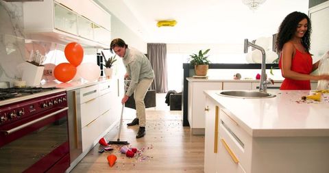 Couple cleaning up after festive party in modern kitchen