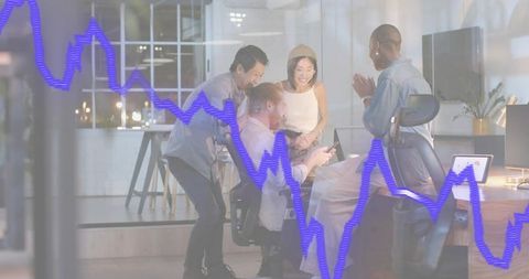 Diverse team collaborating around devices with financial analytics overlay on office chart