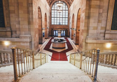 Grand library interior with ornate staircase and chandeliers