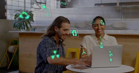 Colleagues collaborating with augmented reality icons over laptop in modern coworking cafe