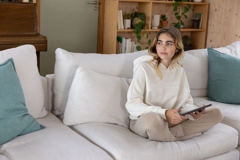 Woman Using Tablet on Elegant White Sofa in Cozy Home