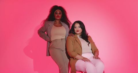 Diverse women posing in chic neutral blazers on pink gradient backdrop fashion editorial