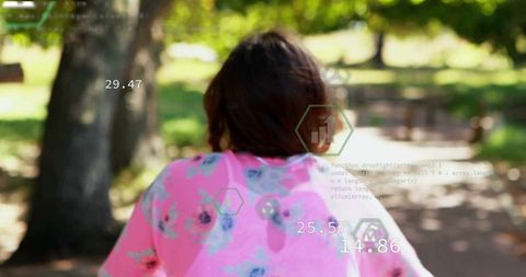 Teenage Girl in Floral Top Exploring Park with Futuristic HUD Overlay