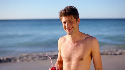 Relaxed Man Enjoying Tropical Drink on Sunny Beach