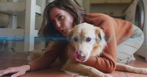 Woman Embracing Golden Dog Next to Washing Machine