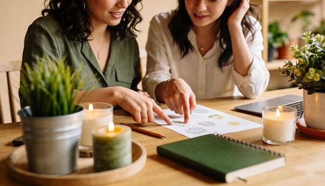 Creative duo collaborating on botanical pattern designs and branding, cozy studio workspace