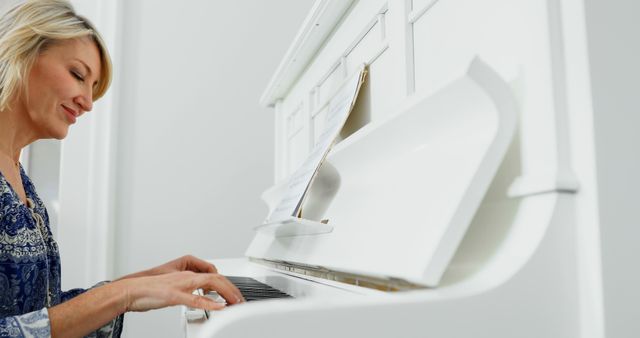 Woman Smiling While Playing White Piano at Home - Download Free Stock Images Pikwizard.com