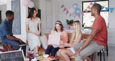 Mixed Friends Celebrating Baby Shower in Cozy Living Room