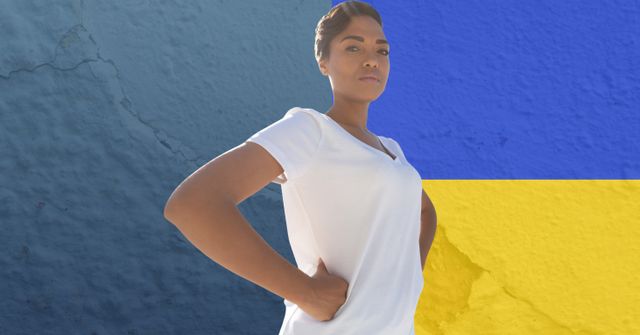 African American woman confidently standing with hands on hips against backdrop of Ukraine flag. Symbolizes strength, solidarity, and support. Useful for articles on international relations, activism, and crisis awareness, as well as promotional material for organizations supporting Ukraine.