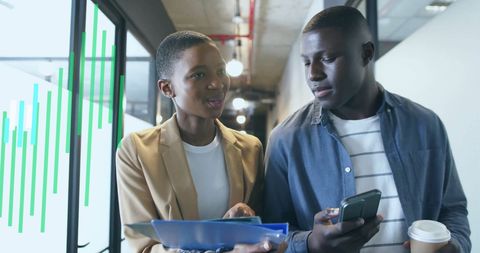 Colleagues Analyzing Data in Modern Office Corridor