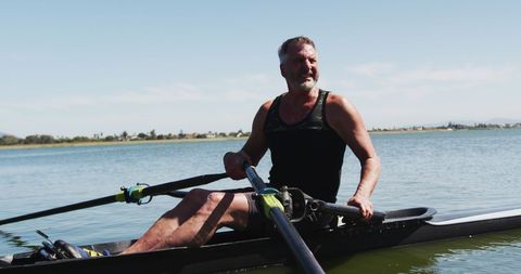 Senior man rowing on tranquil river water outdoors