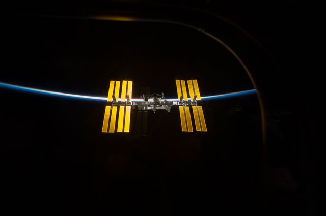 This image shows the International Space Station (ISS) against the dark backdrop of space with Earth’s atmosphere as a thin blue line, as photographed from Space Shuttle Discovery on March 25, 2009. It captures the separation phase after cooperative work between the STS-119 and Expedition 18 crews. Useful for themes related to space exploration, science, technology, NASA missions, and the beauty of outer space.