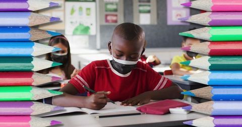 Diverse Children Wearing Masks Studying with Pencils Framing Classroom
