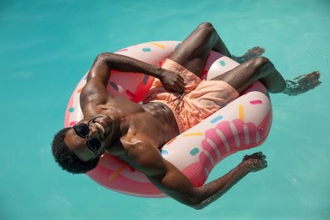 Man Relaxing on Pool Float with Sunglasses on Sunny Day