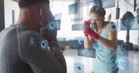 Female boxer sparring with trainer using augmented reality workout interface
