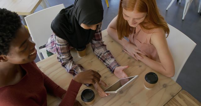 Diverse Group of Women Collaborating Over Tablet at Coffee Shop - Download Free Stock Images Pikwizard.com