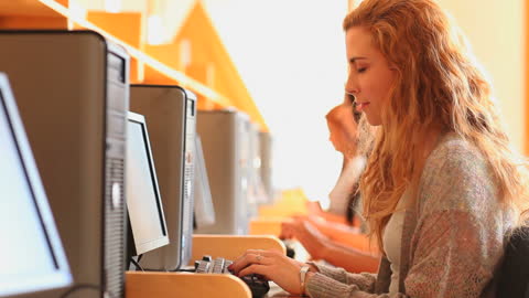 Female Student Using Computer in Bright Library Environment