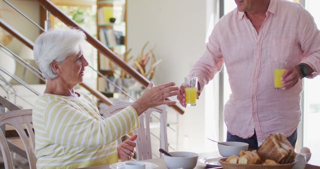 Senior Couple Enjoying Breakfast and Orange Juice Together in Bright Kitchen - Download Free Stock Images Pikwizard.com