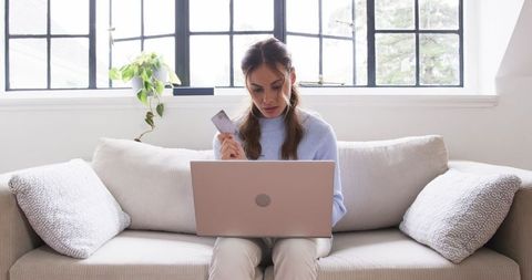 Woman Relaxed with Laptop and Credit Card in Modern Living Room