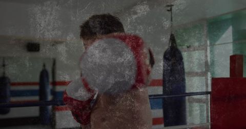 Shirtless boxer throwing straight punch in boxing ring with red glove, powerful impact