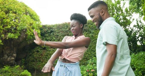 Joyful proposal moment with smiling couple in lush green garden
