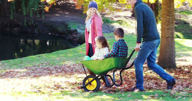 Family Enjoying Outdoor Autumn Day with Children in Wheelbarrow - Download Free Stock Images Pikwizard.com