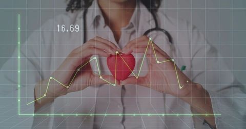 Female clinician holding red heart showing ecg data overlay and cardiology analytics