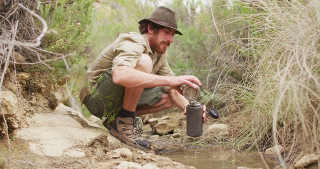 Man Collecting Water from Stream in Wilderness with Canteen - Download Free Stock Photos Pikwizard.com