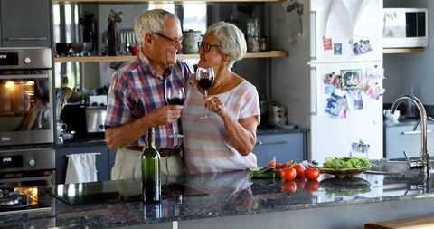Senior Couple Enjoying Wine Together in Modern Kitchen