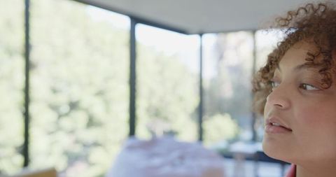 Thoughtful Woman Gazing Out Modern Floor-to-Ceiling Windows