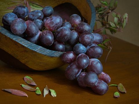 Fresh red grapes in rustic wooden bowl