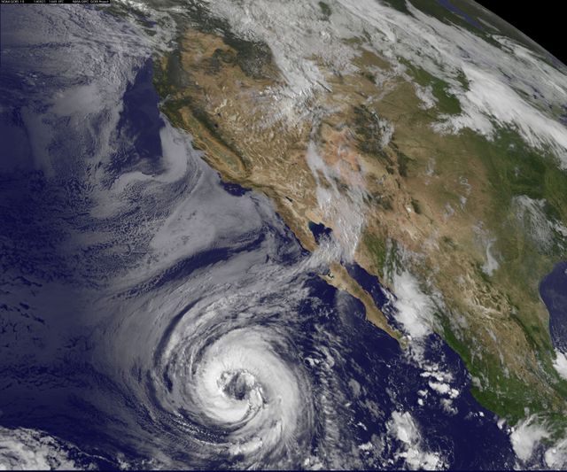 This image captured by NASA's GOES-West satellite shows Hurricane Lowell over the Pacific Ocean on August 21, 2014. Visible with a distinct eye, the hurricane is located southwest of Baja California, Mexico. This satellite imagery is useful for weather forecasting, climate studies, and educational purposes, as it provides a detailed look at storm intensity and movement.