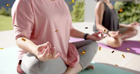 Teen partners meditating outdoors on mint and purple mats with gold confetti for wellness