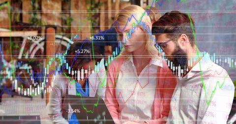 Collaborating team analyzing stock market data on laptop with candlestick charts overlay