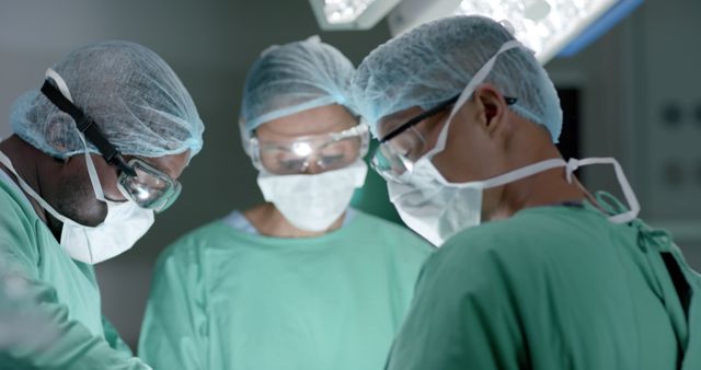 Diverse surgeons with face masks during surgery in operating room in slow motion. Medicine, health and care.
