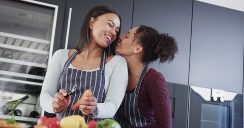 Happy Biracial Couple Cooking and Sharing Affection in Modern Kitchen