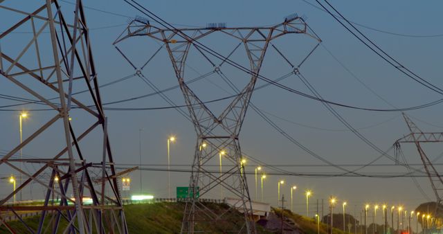General view of electricity pylons over lamps and blue sky. Electricity, energy, environment and transmission.