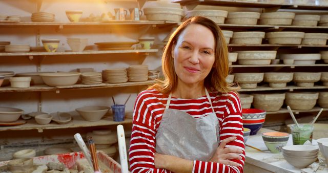 Confident Female Potter in Workshop with Shelves of Ceramic Wares - Download Free Stock Images Pikwizard.com