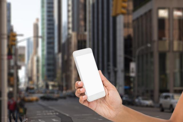 Composite image of hand holding smartphone with the street background 
