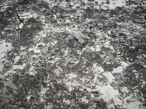 Textured grunge concrete surface with peeling paint